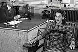 Black and white photo from the 1950s illustrating a woman with a distant stare while taking a polygraph/ lie detector test.