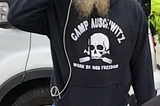 A racist. His shirt says “Work Brings Freedom.” These words hang at Auschwitz, where so many perished during the Holocaust.