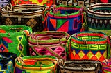 multiple colorful with distinct geometric patterns baskets lined up in rows