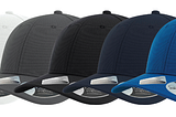 The SAND Sustainable Performance Cap in white, gray, black, navy, and royal blue.