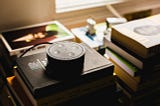 Amazon smart speaker with voice technology sits on books and publications.