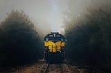 Train on tracks, coming toward viewer, a misty, rainy scene