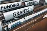 File folders in a drawer with tabs labeled GRANTS, FUNDING and PROJECTS.