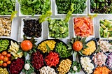 colorful salad bar with a wide variety of vegetables, meats, and cheeses