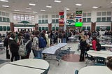 400 students gathered in a cafeteria between classes. Only one is on her phone.