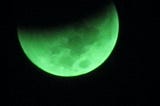 A picture of a green shaded partial lunar eclipse.