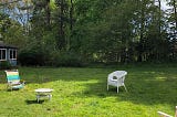 socially-distant chairs and table on lawn