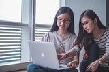 Women looking at one computer