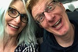 a woman with blue hair making a funny smiling face with a man who is also making a goofy face