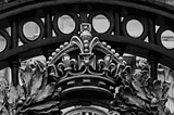 The crown on Buckingham Palace’s gates in black and white.