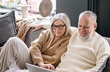 Older couple at home looking at a laptop screen.