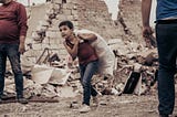 A young boy walks past buildings destroyed in a rocket attack on Ganja, Azerbaijan’s second city. Image: Orkhan Rahmanli