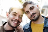 Two close male friends with their arms around each other.