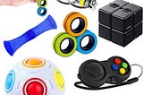 Several different fidget toys shown, including a ball, two sets of rings, a clicking switch, a folding square, and a sliding net with a ball in it.