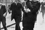 The leader of the Women’s Suffragette movement, Mrs Emmeline Pankhurst is arrested by Superintendant Rolfe outside Buckingham Palace, London while trying to present a petition to HM King George V in May 1914. (Image source: Public Domain).