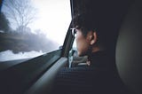 a man sitting in the car looking out the window