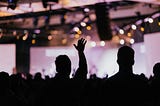 Photo of people raising hands in a concert