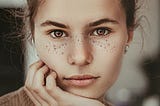 Portrait of a woman showing off her unique freckly features