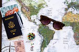 A map of the world with a passport and sunglasses, because you still should travel the world even with a chronic illness or disability