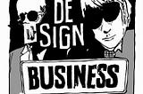 Two people in suits wearing sunglasses with a sign that says “Design Business”.