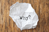 Crumpled paper with ‘why?’ typed on it.