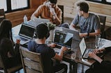 People working at a desk like a startup team.