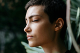 A short haired woman with eyes closed
