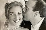 A groom kisses his bride on their wedding day.