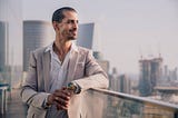 handsome man in suit overlooking skyline with a smile