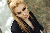 Blonde woman in black outfit staring up at camera