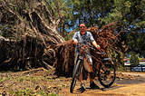 I am standing next to the tree with my bike.