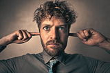 A man plugging his ears.