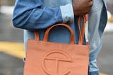 A shopper with a brown Telfar shopping bag