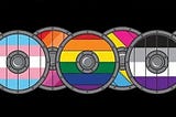 A set of ten Viking shields arranged in a horizontal, overlapping shield wall are decorated with various pride flag colours, including the standard rainbow pride flag colours, the transgender/gender diverse colours and the asexuality flag colours