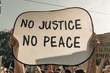 A banner with the words No Justice No Peace, Nyk, Medium