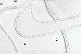 A close up profile crop of a Nike Air Force 1 shoe in all white