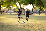 Two brothers spend quality time together playing soccer in the fields of Mitchell Park in Tempe, Ariz.