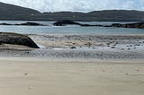scene at Derrynane beach overlooking peninsulas and rocks.