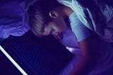 Child fallen asleep next to parent’s laptop