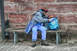 homeless man digging through shopping bag