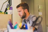 A man staring at a computer screen in an office