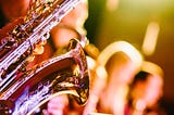 Saxophone player and backing vocal singers — Photo by Jens Thekkeveettil on Unsplash