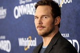 A photo of Chris Pratt wearing a black suit at the premier of the Pixar movie Onward.