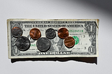Screenshot of a dollar bill plus coins