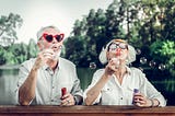 Baby Boomers man and woman couple blowing bubbles. G. K. Hunter