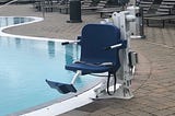 Swimming pool with assisted chair device next to it.