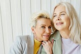 Two middle aged women posing together as friends
