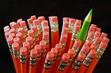 One green pencil amongst red ones. Odd one out. Barbara Cook blogger