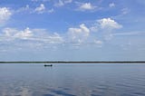 A lone fishing boat sits in the vast surrounding waters of Lake Jesup, Florida