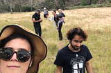 A group of people walk across a field towards the camera.